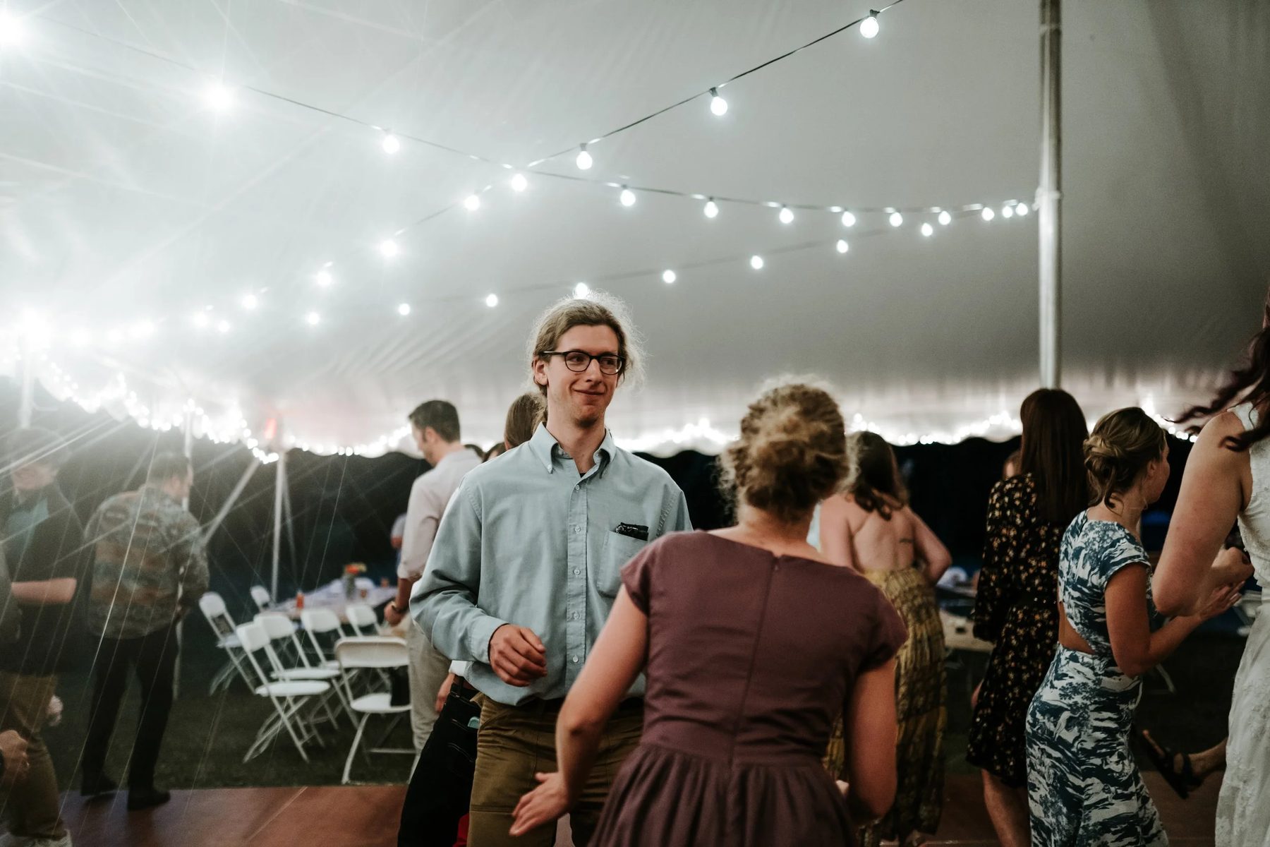 Guests dancing under a lit tent