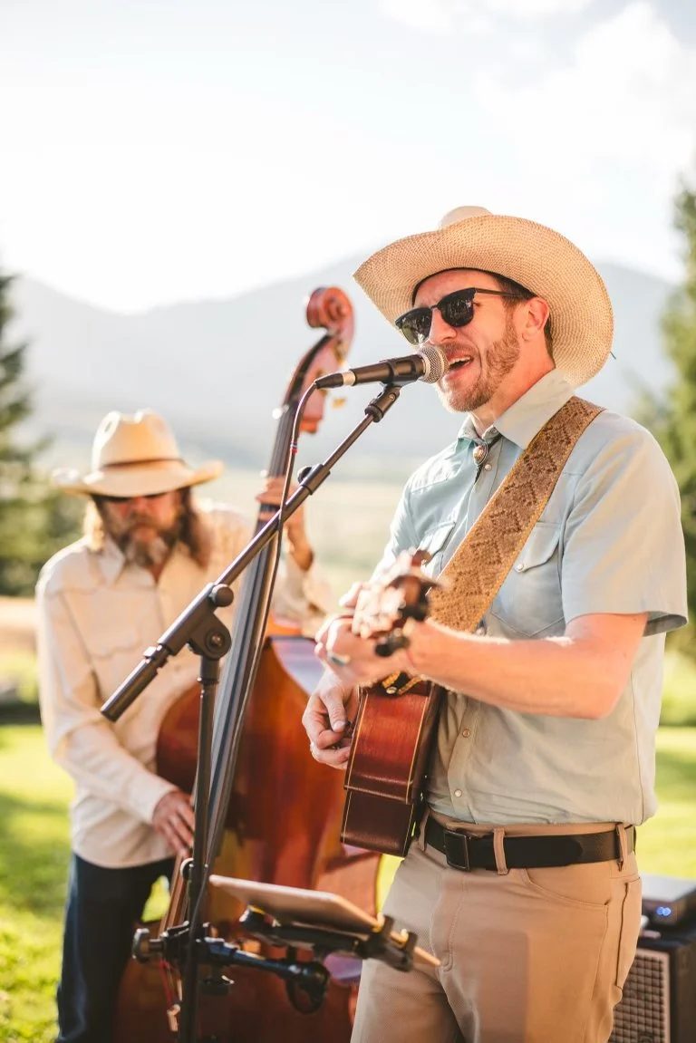Two musicians playing guitar and upright bass outdoors
