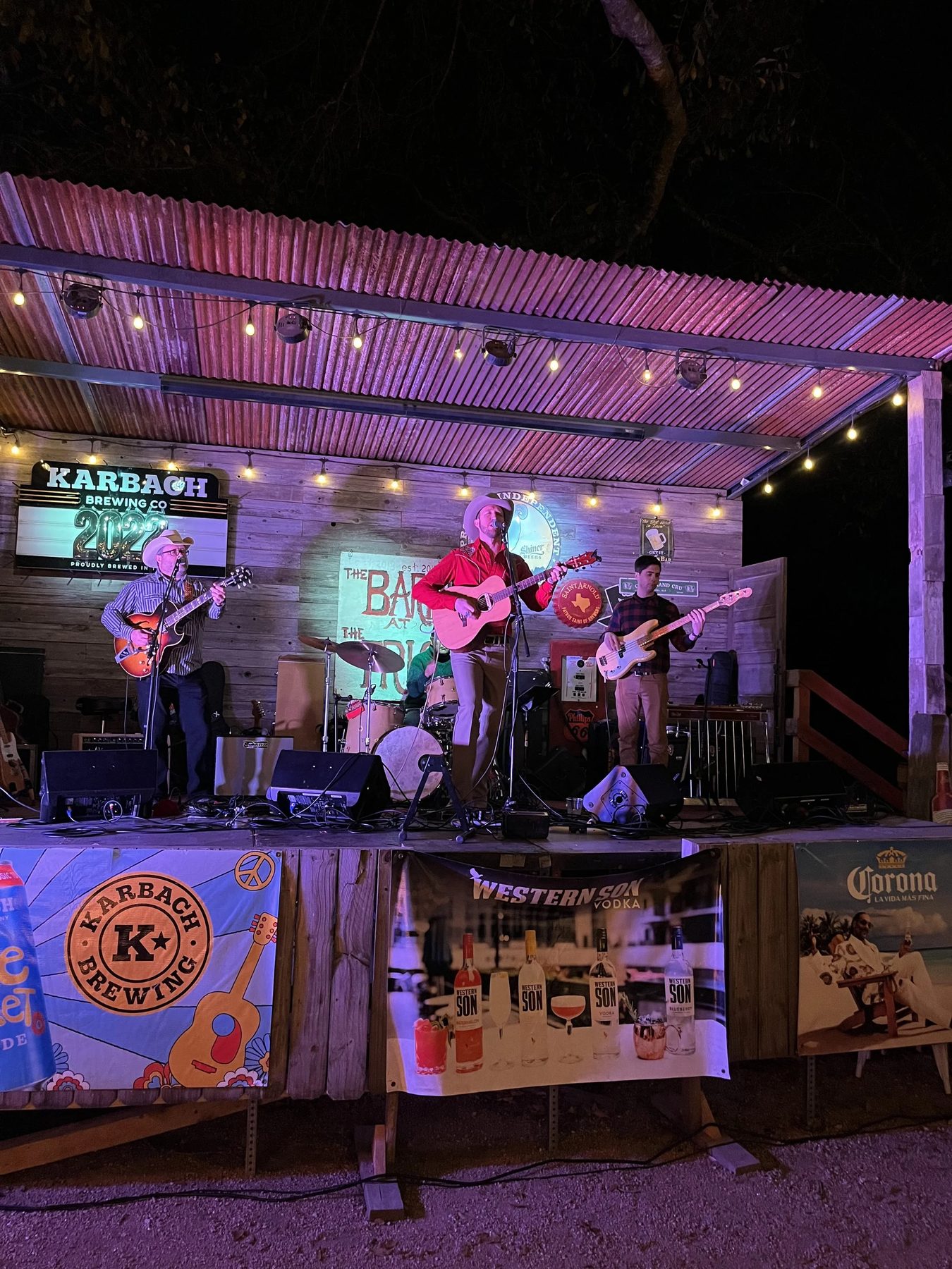Full band playing a lit stage